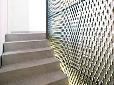 A stair wall is made of decorative expanded metal mesh.