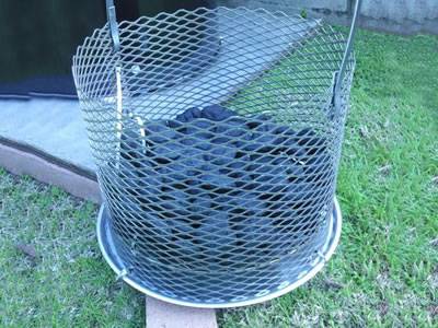 Several charcoals in the expanded metal charcoal basket.