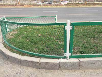 緑の膨張した金属板が道路の緑の帯を囲んでいます。