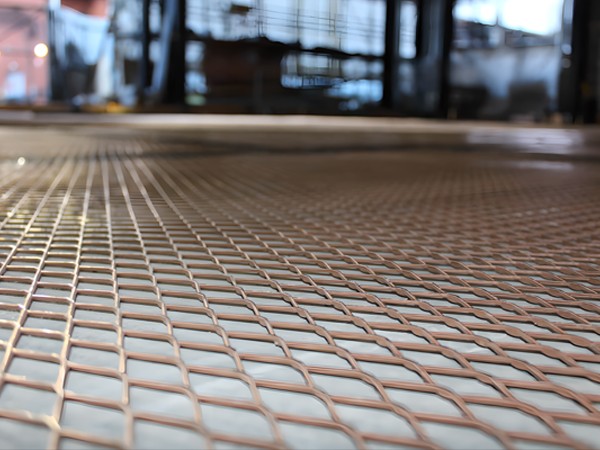 A copper expanded metal sheet laid flat on the floor