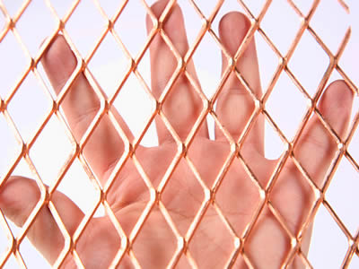 A hand is holding the copper expanded metal.