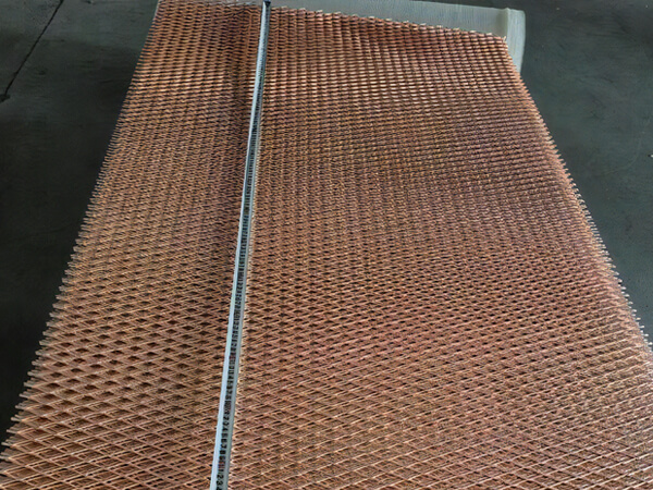 Um trabalhador está medindo o comprimento da malha expandida de folha de metal de cobre.