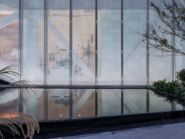 A building by the water has decorative expanded metal mesh installed.