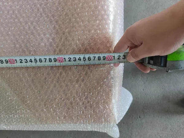Worker measuring the length of the expanded copper mesh with a tape measure as 300.7 cm