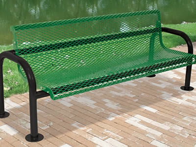 A green painted expanded metal bench in the park with a lake beside it.
