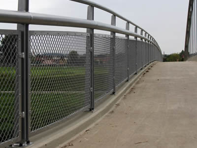 On the edge of the endless green farmland, expanded metal as handrail of a bridge.