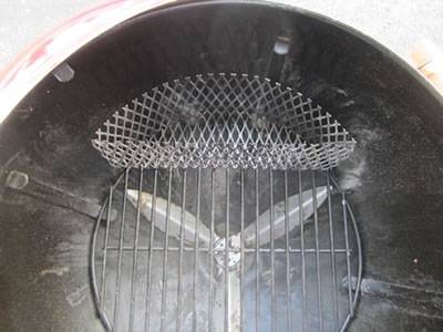 A arch expanded metal charcoal basket in the stove.