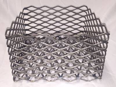 A square expanded metal charcoal basket on the gray background.
