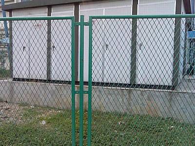 Des clôtures de sécurité en métal expansé entourent la boîte électrique.