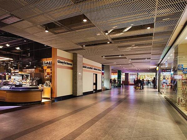 Installation of expanded metal sheet on the ceiling of a mall corridor.