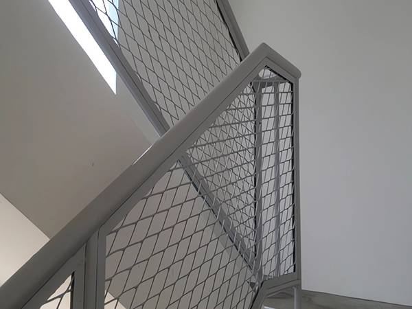 Flattened expanded metal sheet for safety at stairwell railing