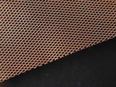 Copper micro expanded metal on a black background