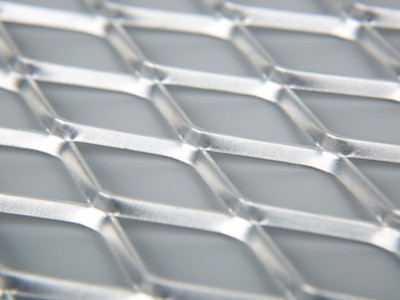 Un morceau d&#39;acier inoxydable a soulevé la feuille de métal déployé sur le fond bleu.