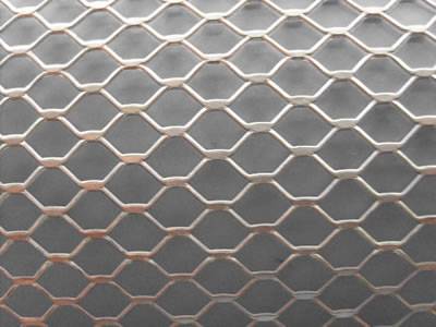 A piece of hexagonal hole steel expanded metal sheet on the blue background.